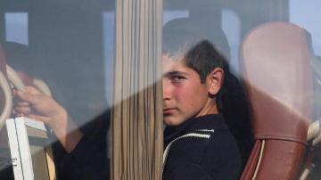 ein Junge schaut aus einem Busfenster