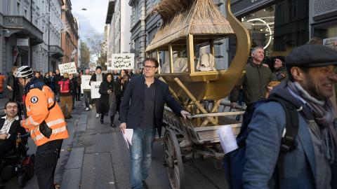 Milo Rau mit dem symbolischen Totenschiff für Schepenese an einem Umzug in der St. Galler Innenstadt