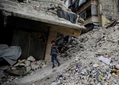 Kind in den Trümmern der zerstörten Stadt Aleppo