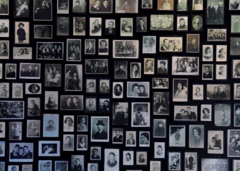 Ausschnitt aus einer Mauer mit Fotos von Deportierten in einer Baracke des ehemaligen Vernichtungslagers Auschwitz