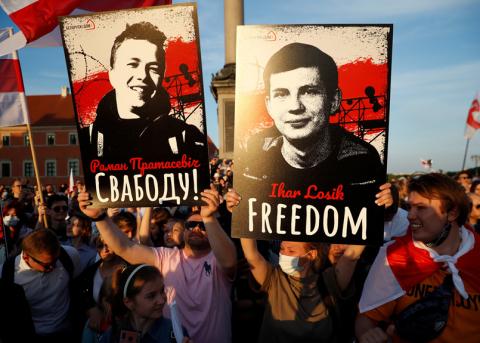 Demonstranten zeigen zwei Plakate mit den Bildern von politisch Verfolgten
