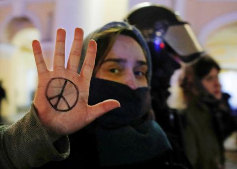 Frau, welche sich das Peace-Symbol auf die Hand gemalt hat, an einem Protest gegen den Krieg in St. Petersburg