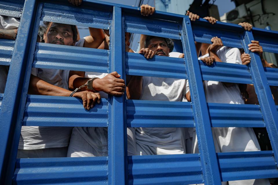 Menschen auf einer Ladefläche bei einem Gefangenentransport in San Salvador
