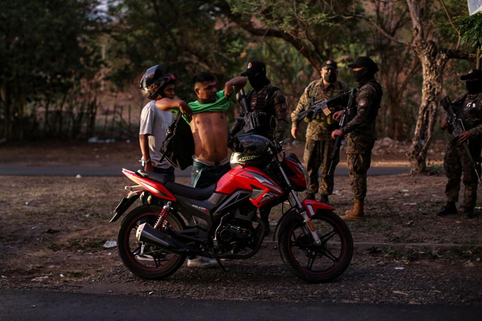 zwei junge Männer mit einem Motorroller werden von einer Spezialeinheit kontrolliert