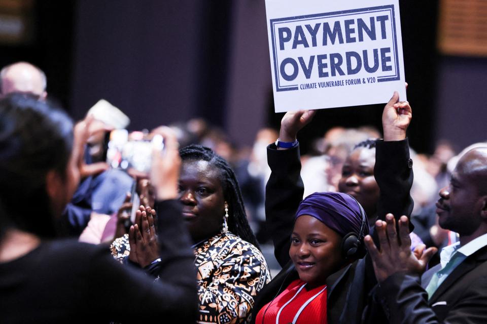eine Aktivistin hält an der COP27 ein Schild mit der Aufschrift «Payment Overdue» hoch