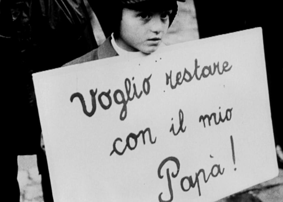 Ein Kind hält ein Schild: Voglio restare con il mio Papa! (Ich möchte bei meinem Vater bleiben!)