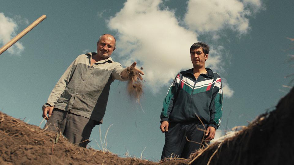 Filmstill aus dem Film «Carbon»: zwei Männer werfen Erde in ein Grab