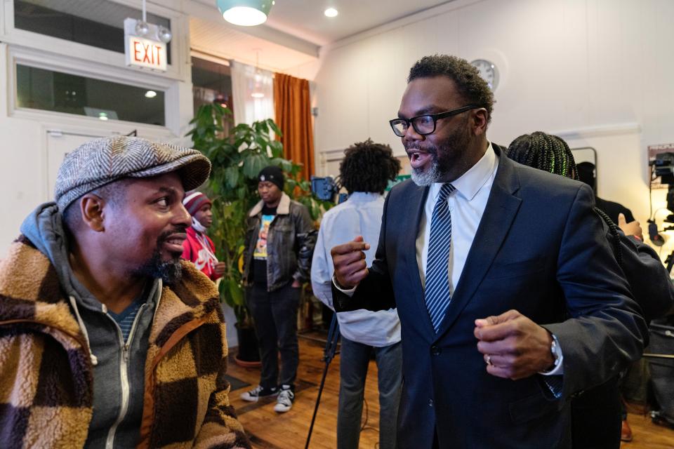 Bürgermeisterkandidat Brandon Johnson im Gespräch mit einen Mann an einer Wahlveranstaltung im Dezember