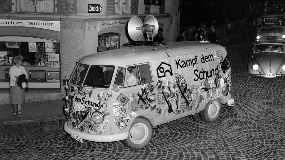 Aktion gegen «Schundliteratur» 1965 in Brugg: ein VW-Bus mit Lautsprecher auf dem Dach und Aufschrift «Kampf dem Schund» fährt durch die Strasse