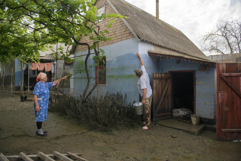Lydiya Bidnitschenko und ihr Schwiegersohn Wolodymyr Saporoschtschenko zeigen wie hoch das Wasser ihr Haus überflutet hat