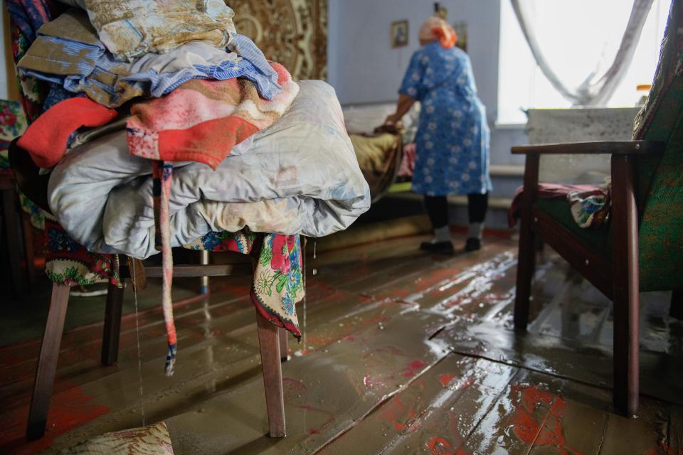 Lydiya Bidnitschenko entfernt nasse Textilien in ihrem überfluteten Haus