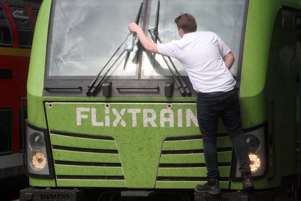  Flixtrain-Lokführer in Frankfurt putzt die Scheibe einer Lokomotive