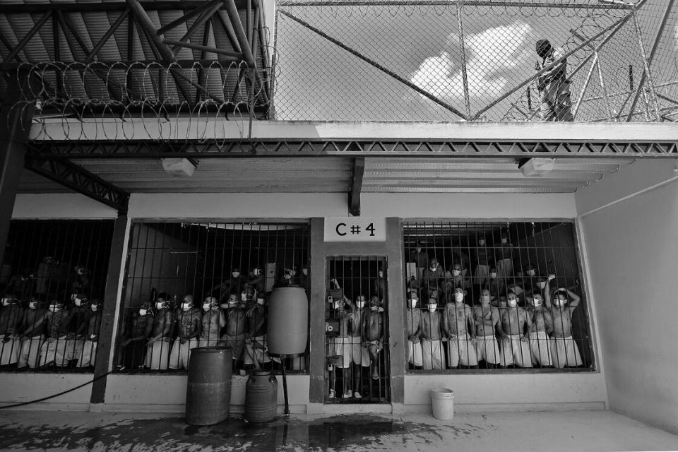 inhaftierte Männer blicken aus einer überfüllten Gefängniszelle