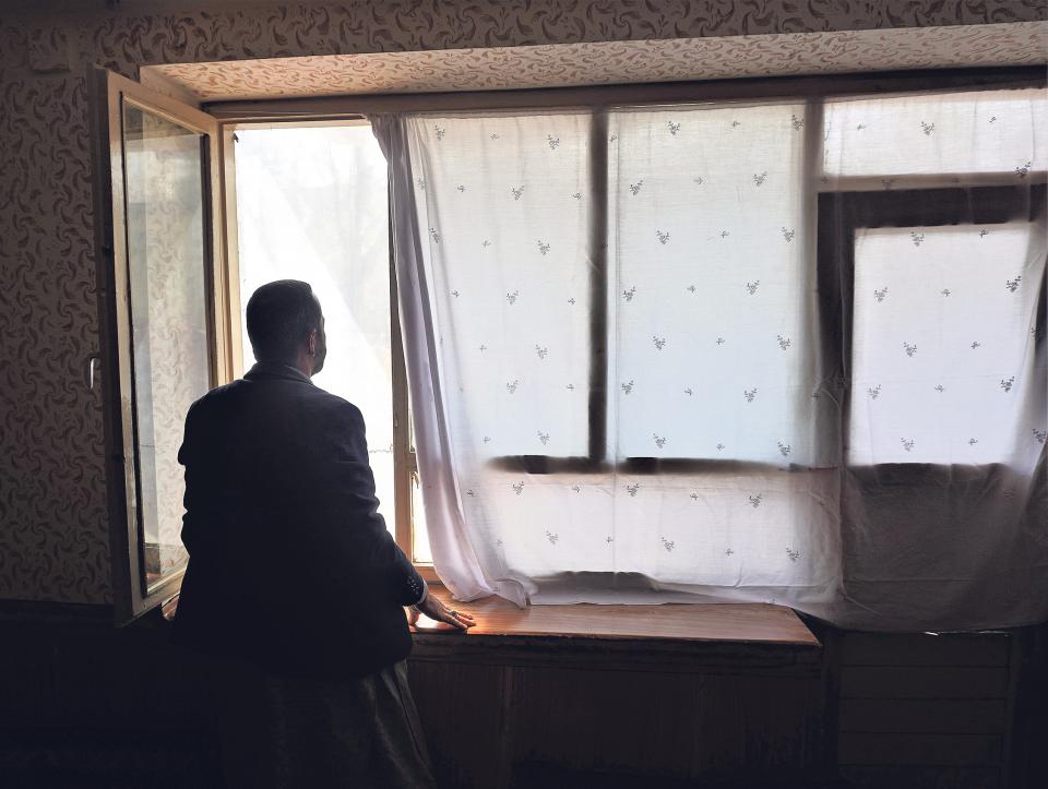 Techniker Mohammad Zahed schaut aus dem Fenster seiner Wohnung